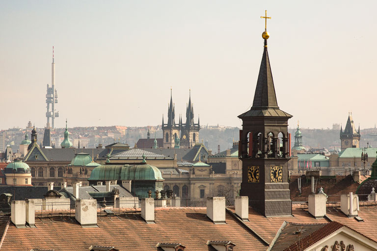 Historic Prague skyline with a large cathedral spire at the center. 