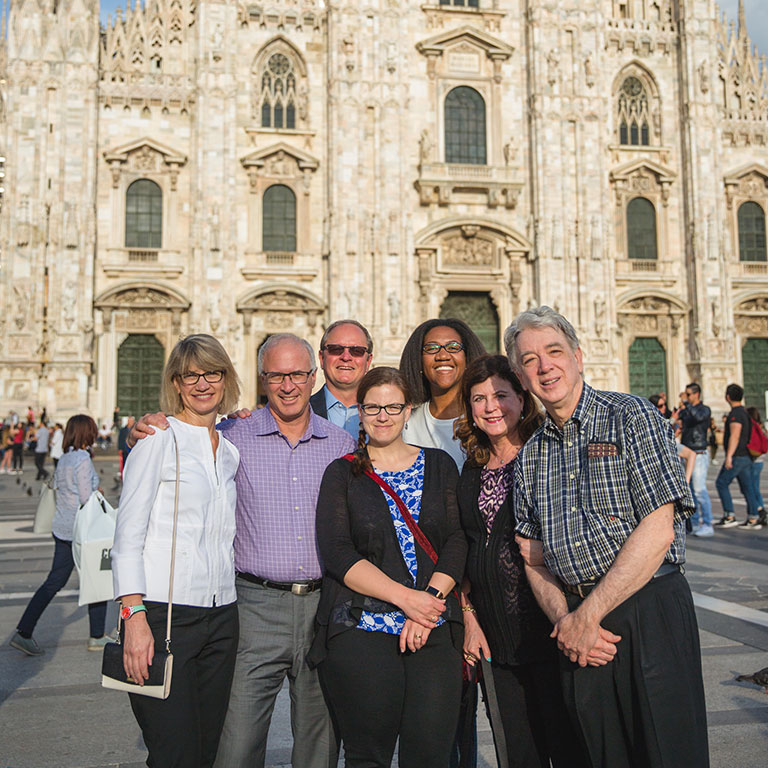 A group of Physician MBA students stand in front of an ornate cathedral in Italy.