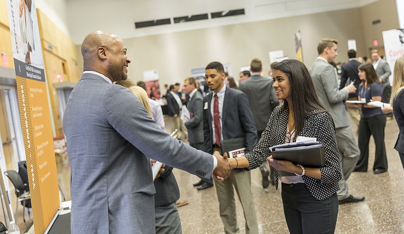 A business student shakes hands with a recruiter at a Kelley Career Fair event on campus.